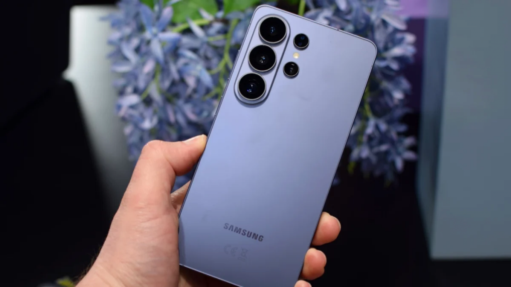 Todo sobre los nuevos Samsung Galaxy S26: IA avanzada, pantalla de 6,3" y la llegada del Ultra 1 Primer plano de una mano sosteniendo un Samsung Galaxy S26 Ultra en color violeta, mostrando el diseño de las cámaras traseras.